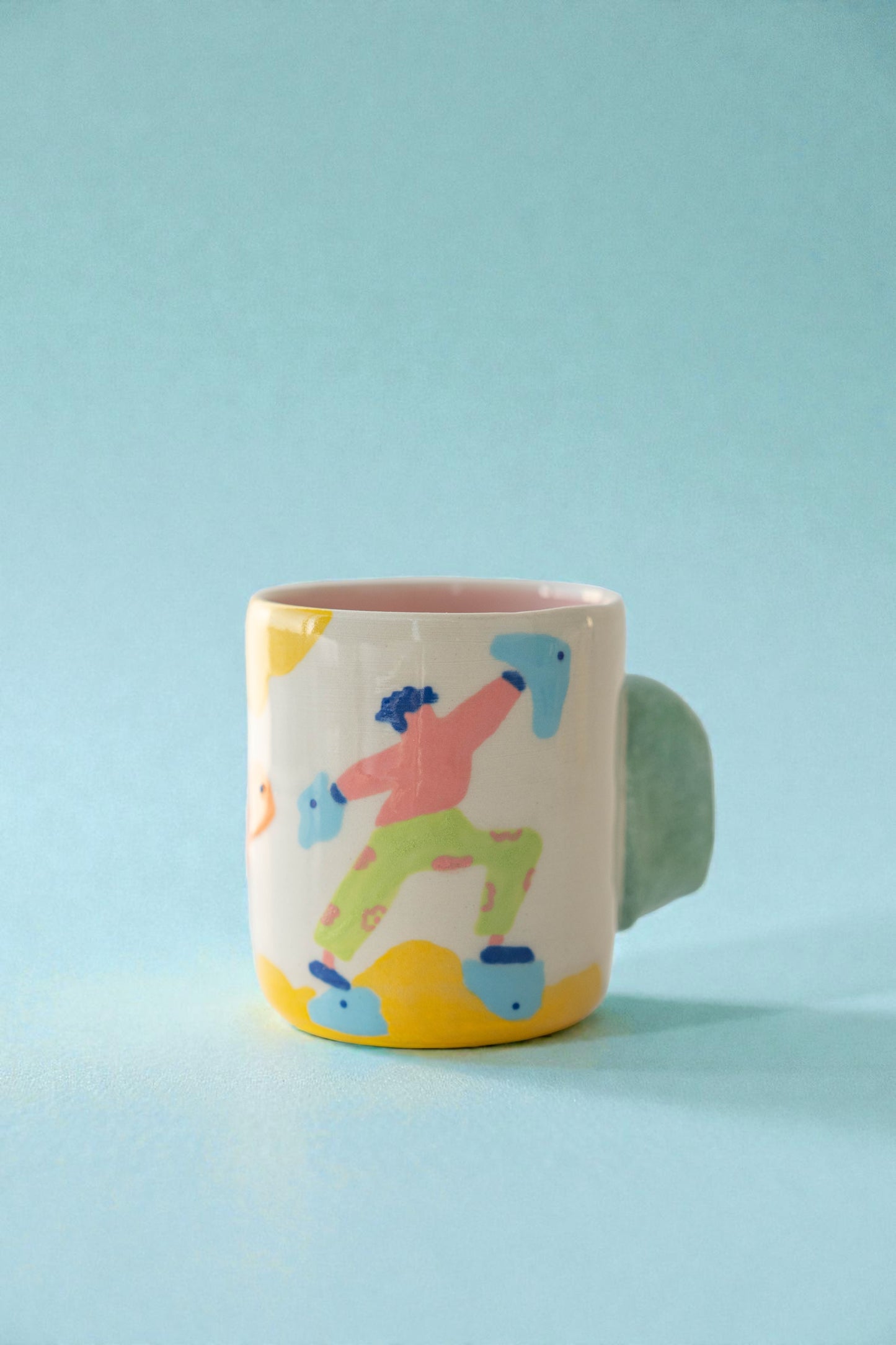 Colorful mug with a design of a person on roller skates against a light blue background