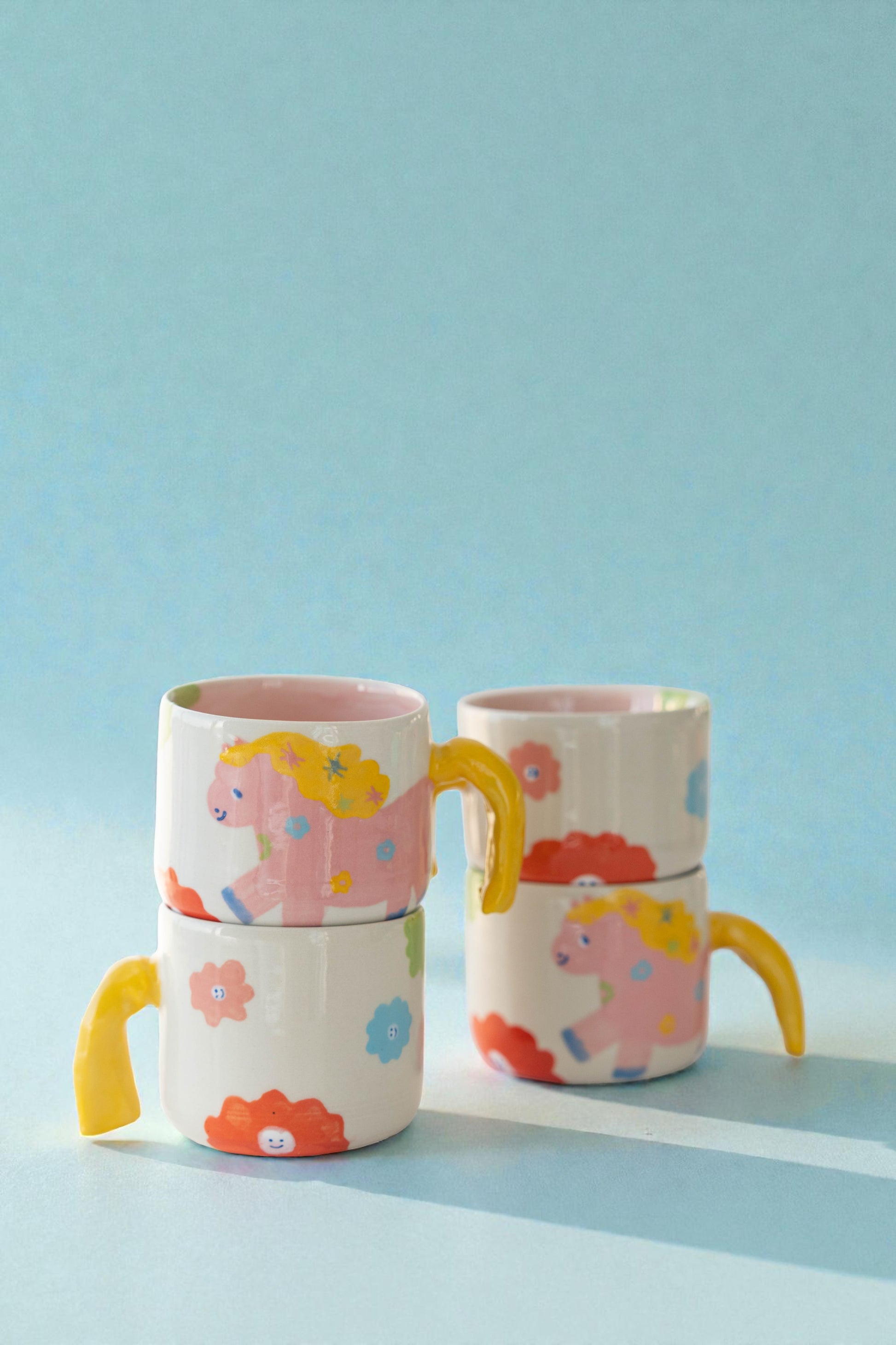 ceramic mug with a pony design and pony tail handle