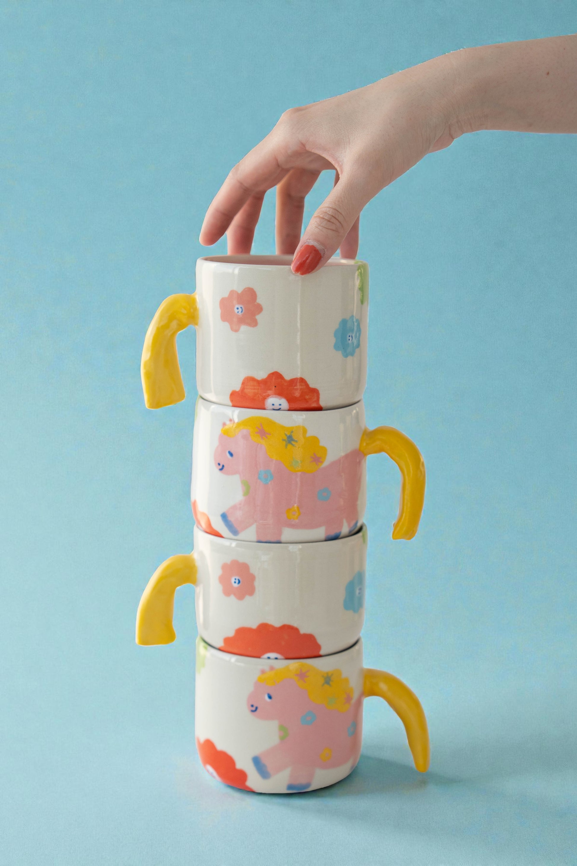 ceramic mug with a pony design and pony tail handle