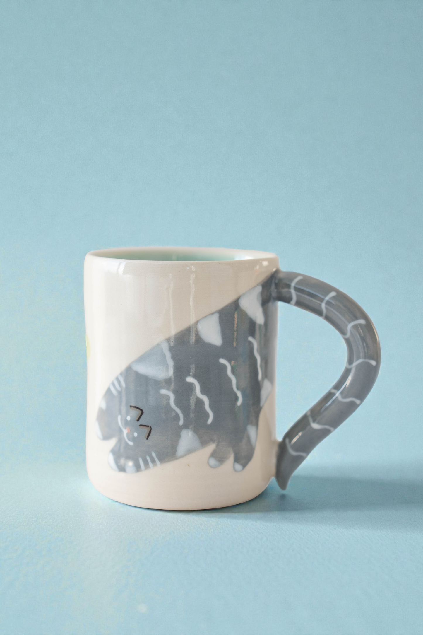 Ceramic mug with a cat design on a light blue background