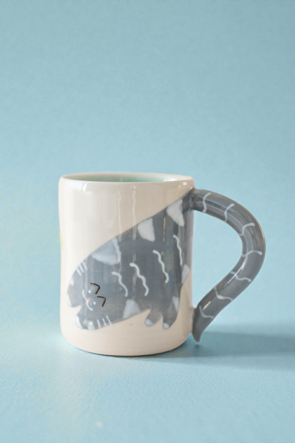 Ceramic mug with a cat design on a light blue background