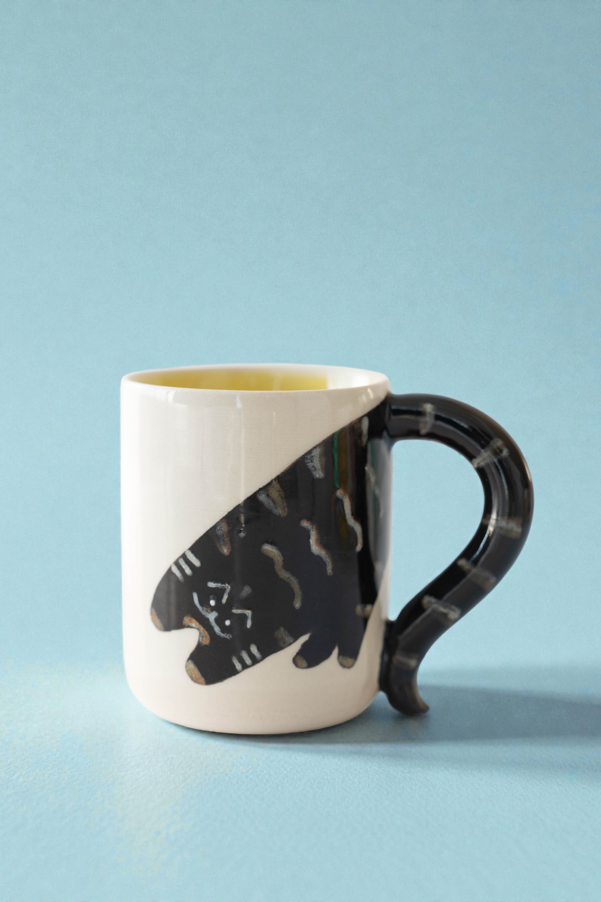 Mug with black cat design on a light blue background